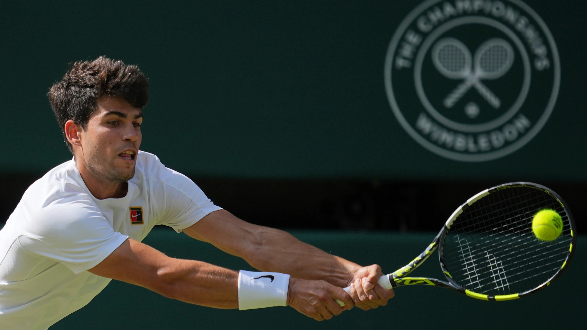 Carlos Alcaraz of Spain returns to Italy's Jannik Sinner in the men's singles final at the Wimbledon Tennis Championships in London, Sunday, July 13, 2025. (AP Photo/Kin Cheung)