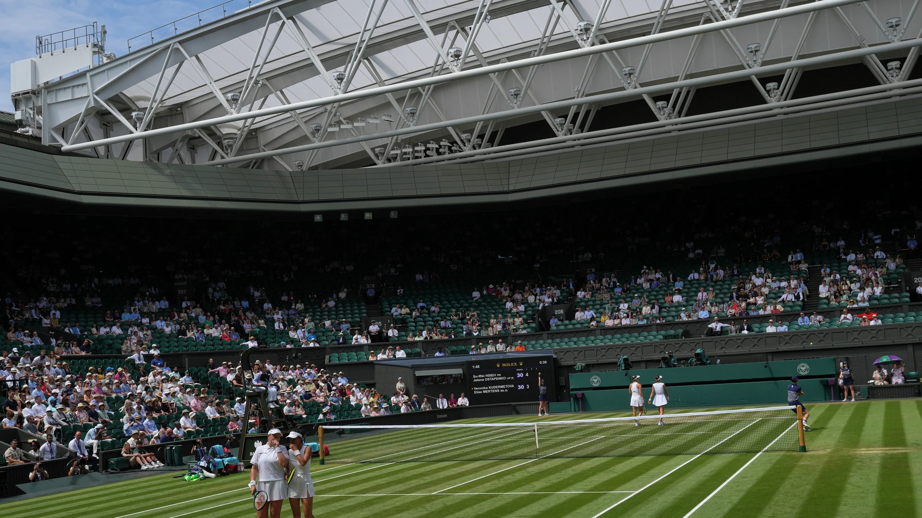 Su-Wei Hsieh of Taiwan, front right, and Latvia's Jelena Ostapenko Veronika Kudermetova confer between points as they play Elise Mertens of Belgium during the women's doubles final at the Wimbledon Tennis Championships in London, Sunday, July 13, 2025. (AP Photo/Kin Cheung)
