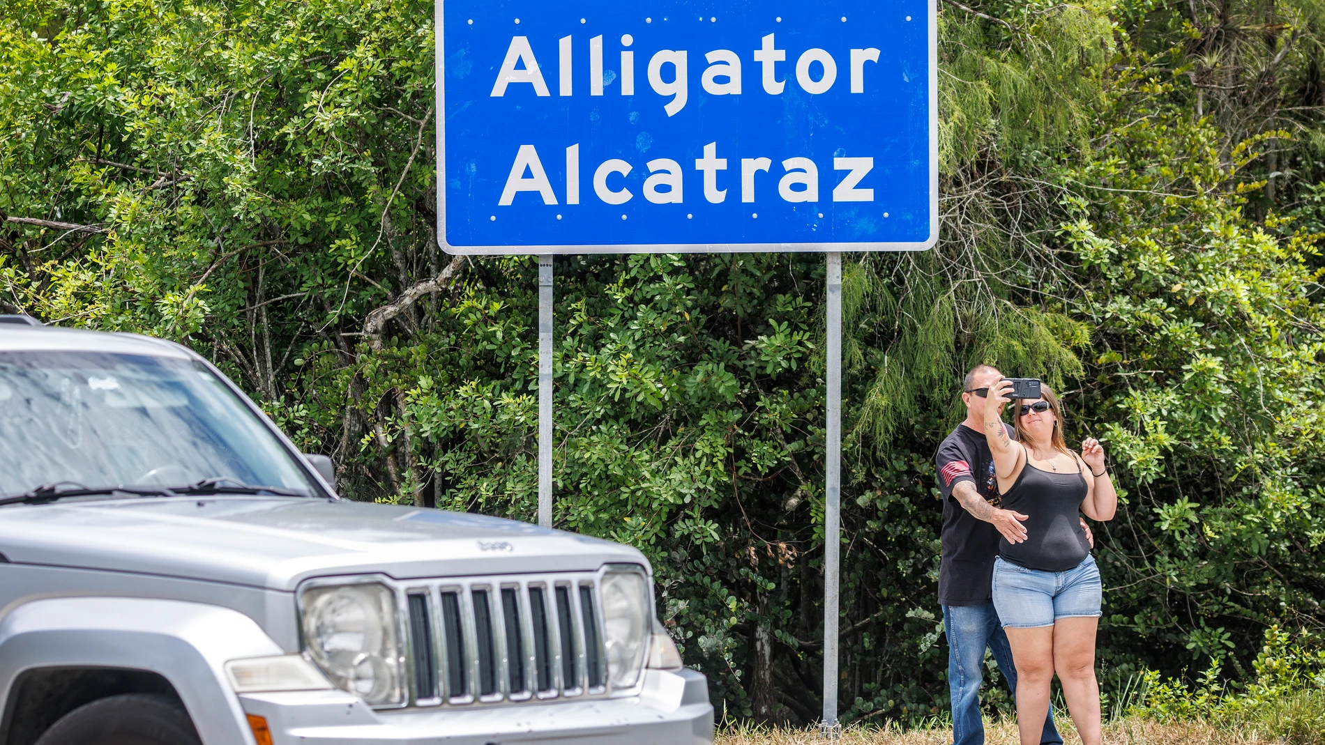 OCHOPEE (United States), 14/07/2025.- People take a selfie next to the new detention center Alligator Alcatraz's entrance in Ochopee, Florida, USA, 14 July 2025. Alligator Alcatraz is an immigration detention facility in southern Florida's Everglades, surrounded by Everglade's wildlife like alligators, Florida panthers and pythons, and snakes as a natural deterrent. EFE/EPA/CRISTOBAL HERRERA-ULASHKEVICH