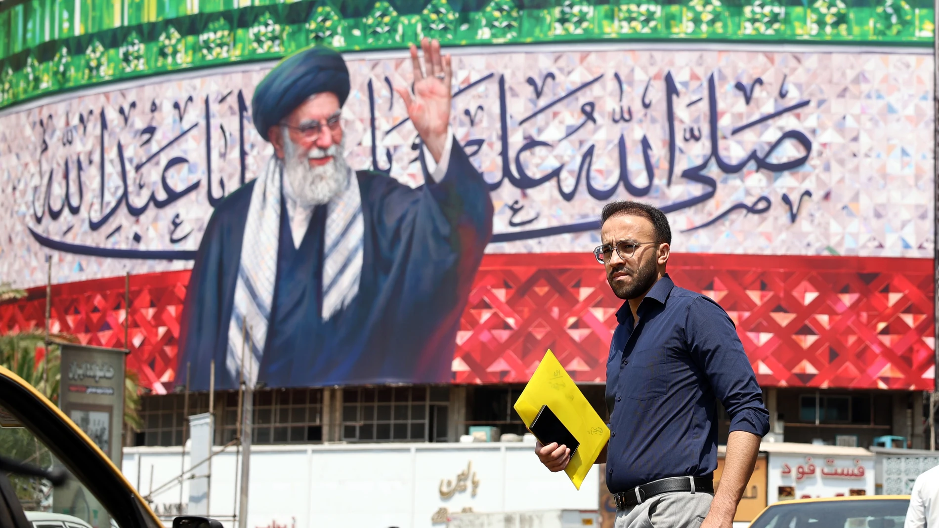 TEHRAN (IRAN(Islamic Republic Of)), 14/07/2025.- A person walks past a billboard featuring a picture of Iranian Supreme Leader Ayatollah Ali Khamenei at Valiasr Square in Tehran, Iran, 14 July 2025. A US-mediated ceasefire between Iran and Israel started on 24 June, ending a new escalation in the conflict that began on 13 June after Israel launched a military campaign across Iran, prompting Iran to conduct retaliatory waves of missiles and drones toward Israel. (Teherán) EFE/EPA/ABEDIN TAHERK...