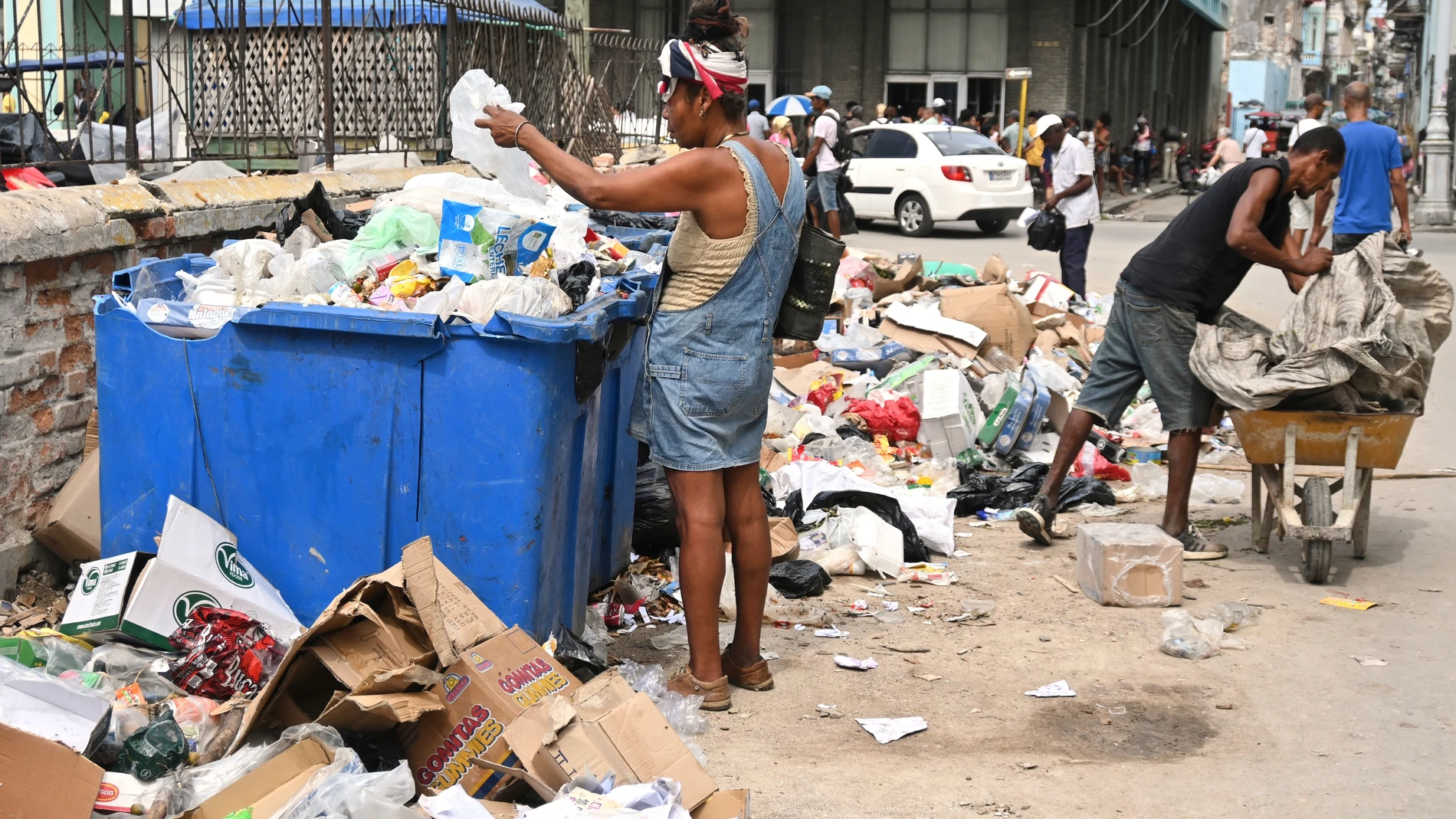 A woman searches through a dumpster looking for useful items, in Havana, Cuba, Tuesday, July 15, 2025. (AP Photo/Jorge Luis Baños)