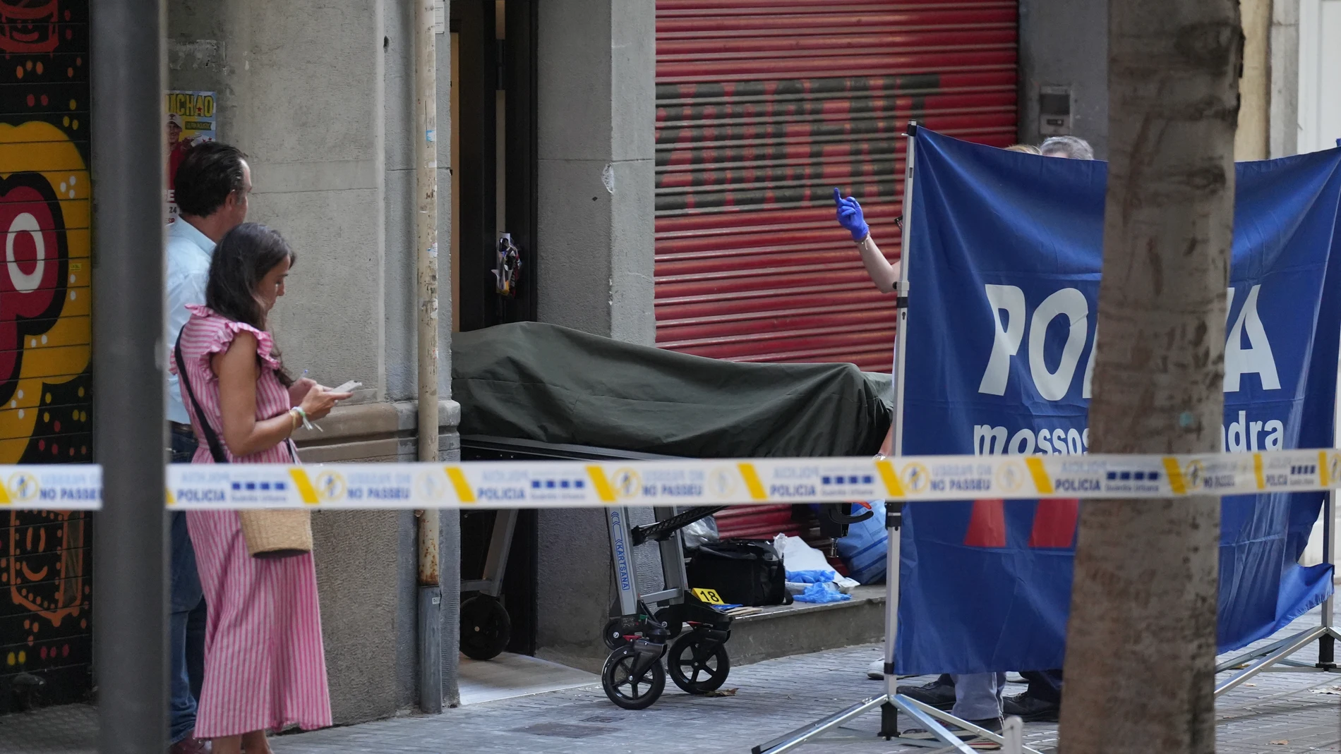 Los servicios funerarios sacan el cuerpo de la víctima, a 15 de julio de 2025, en Barcelona, Catalunya (España). Los Mossos d'Esquadra están investigando el homicidio de un hombre en el distrito del Eixample de Barcelona y aún no hay ningún detenido, según han confirmado a Europa Press. El incidente se ha producido este martes a las 16.25 horas dentro de un portal de la calle Consell de Cent, entre Urgell y Villarroel. Según varios testigos, ha habido un tiroteo, y la división de investigació...