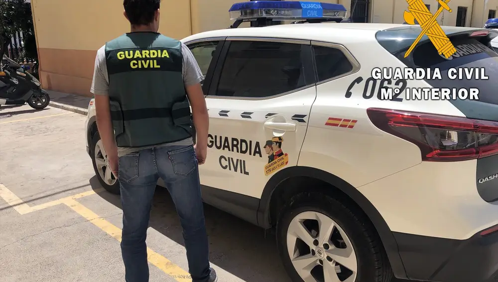 Un agente de Guardia Civil junto a un coche en Almería