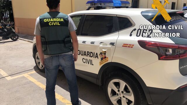Un agente de Guardia Civil junto a un coche en Almería