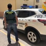 Un agente de Guardia Civil junto a un coche en Almería
