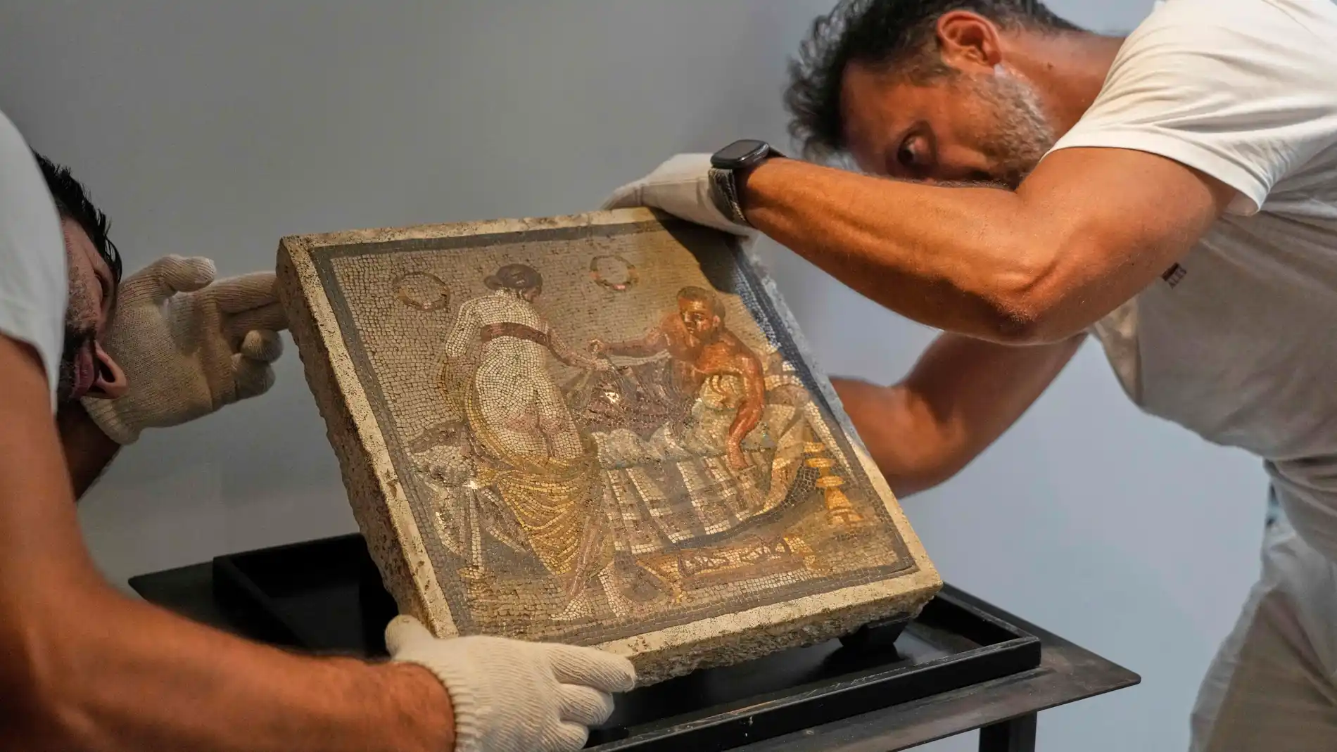 Restorers set on display a Roman mosaic depicting a pair of lovers, which was repatriated from Germany, in Pompeii archaeological park, Italy, Tuesday, July 15, 2025. (AP Photo/Gregorio Borgia)