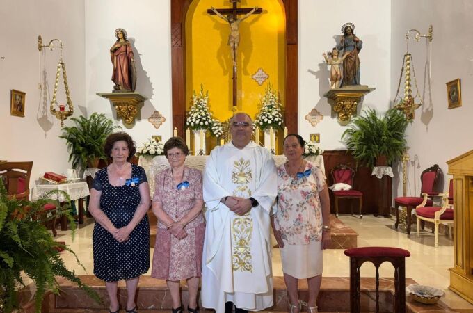 Ángeles posa junto a sus compañeras reconocidas con la medalla y el párroco de Santa Catalina