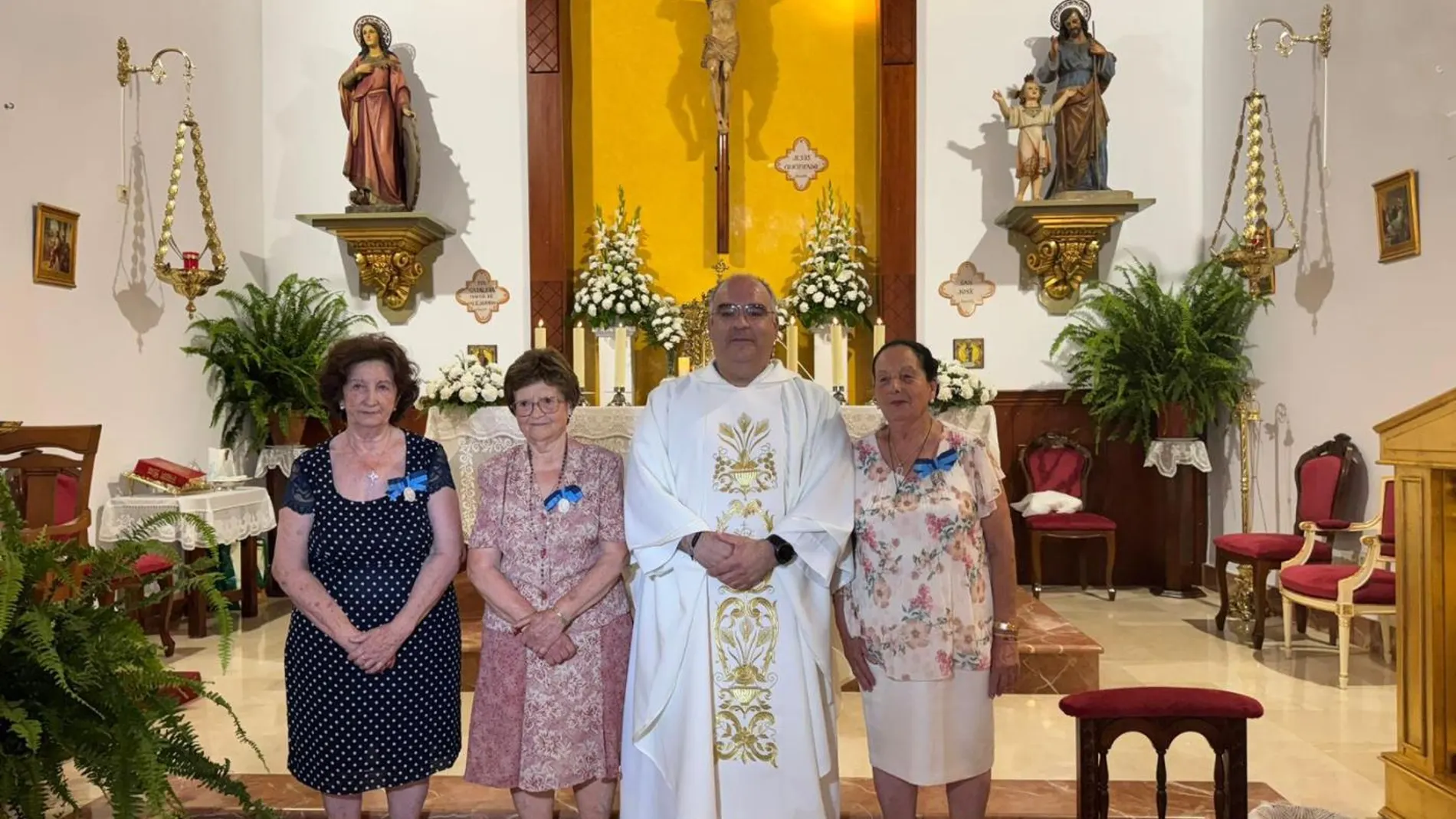 Ángeles posa junto a sus compañeras reconocidas con la medalla y el párroco de Santa Catalina
