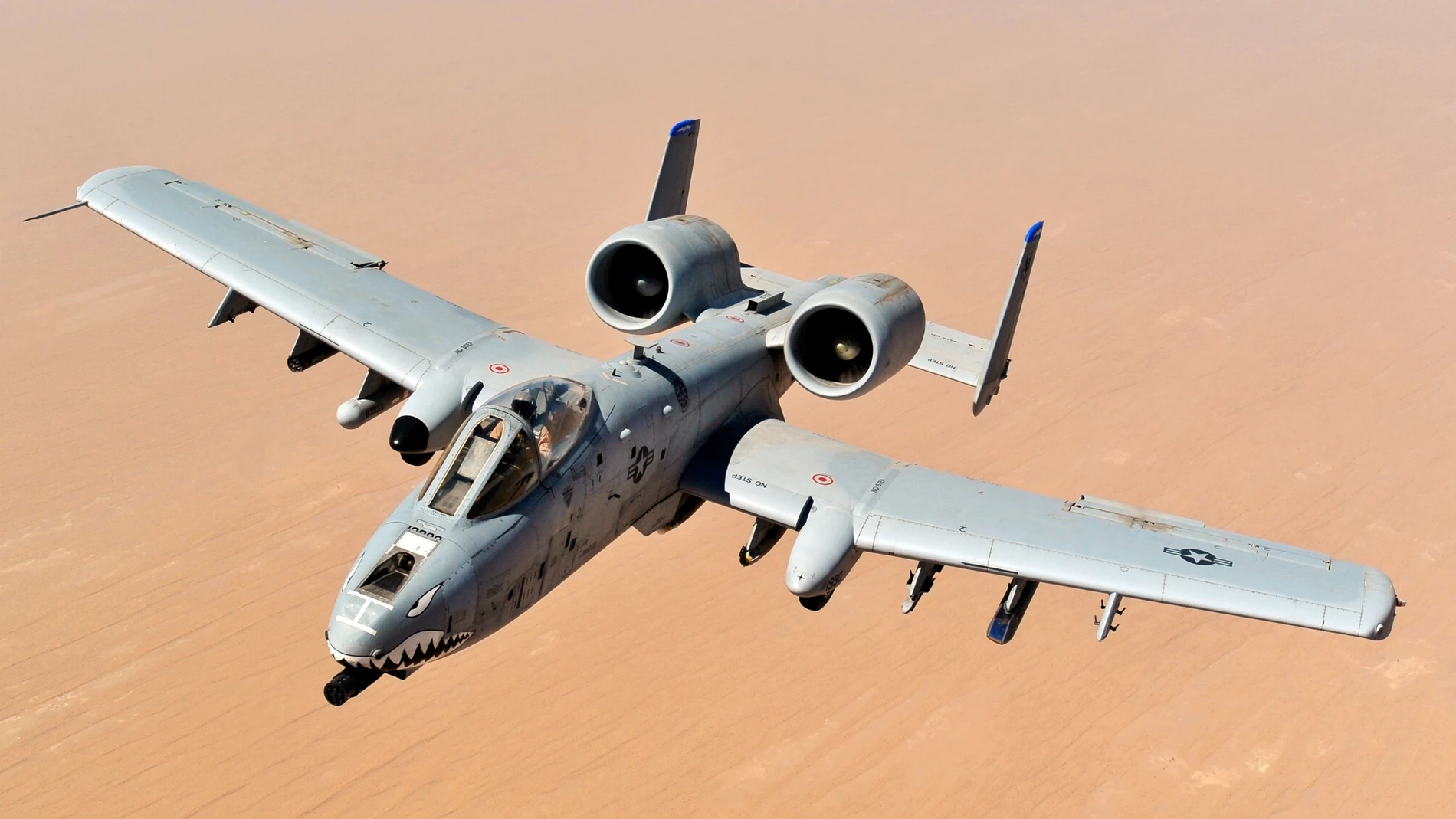 Aparece un avión de combate con un multicañón en su parte delantera volando en mitad del desierto durante unos ejercicios