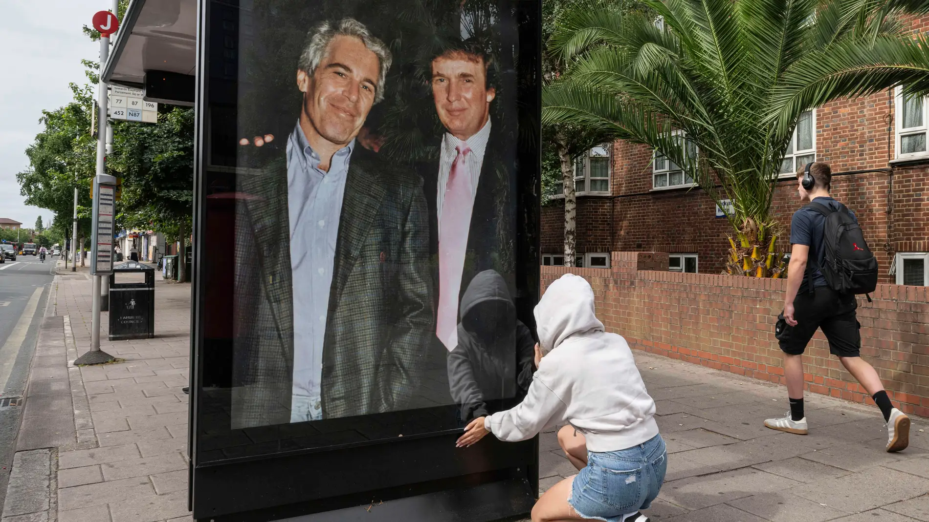 Activists put up a poster showing President Donald Trump and Jeffrey Epstein near the U.S. Embassy in London, Thursday, July 17, 2025.(AP Photo/Thomas Krych)