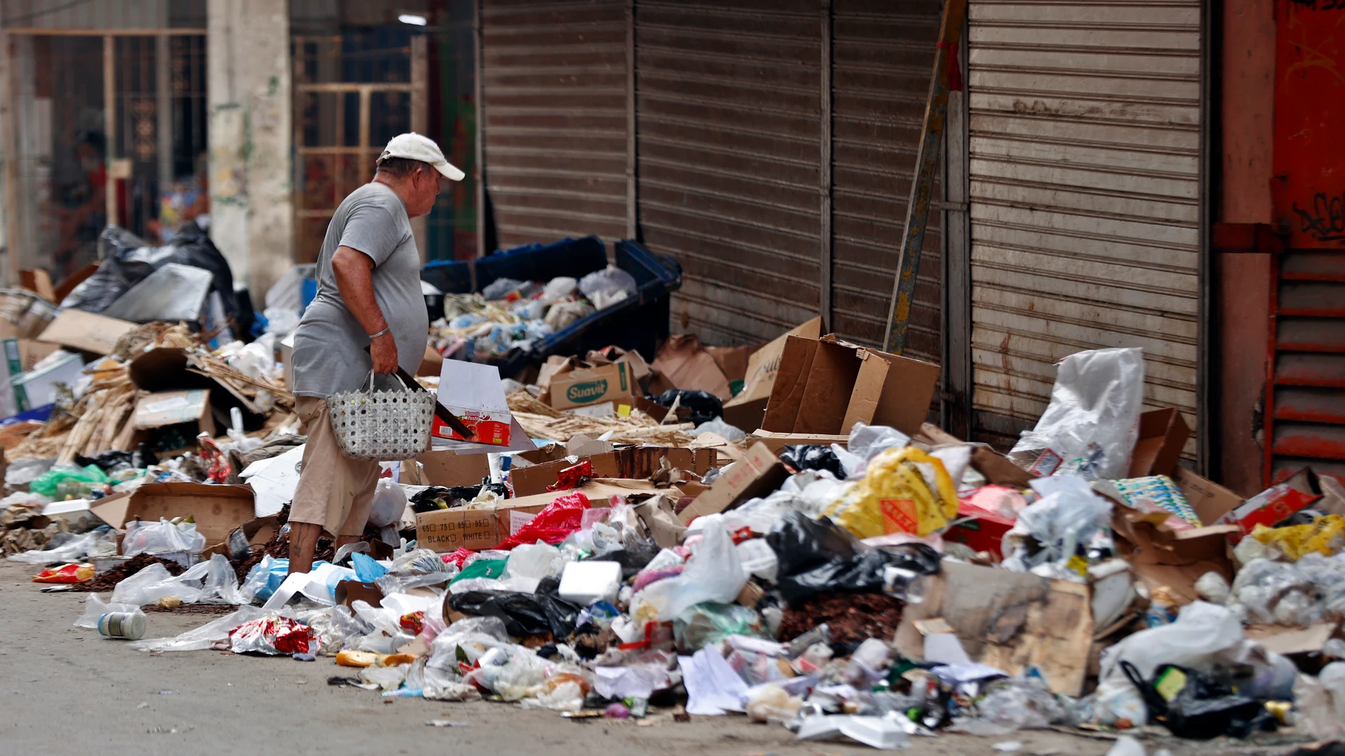 AME3627. LA HABANA (CUBA), 18/07/2025.- Una persona camina buscando cosas en la basura acumulada en una calle este jueves, en La Habana (Cuba). Los años de crisis económica cronificada en Cuba han dejado tras de sí un país con una visible desigualdad y con más gente en el desamparo, según coincidieron expertos consultados por EFE. EFE/Ernesto Mastrascusa