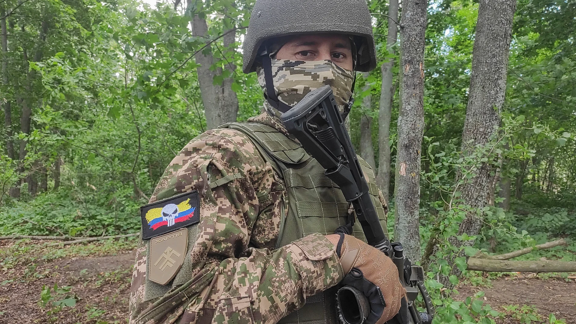 JÁRKOV, 18/07/2025.- 'Craneo', exsoldado del ejército colombiano y soldado voluntario de la unidad 'Guajiro'. En un campo de entrenamiento boscoso en la región ucraniana de Járkov, en el este del país, un grupo de hombres uniformados, muchos con parches que los identifican como colombianos, escucha atentamente a su instructor ucraniano. Son parte de la unidad 'Guajiro', un contingente de combatientes extranjeros dentro de la Brigada Jartia de la Guardia Nacional de Ucrania. EFE/ Rostyslav Ave...