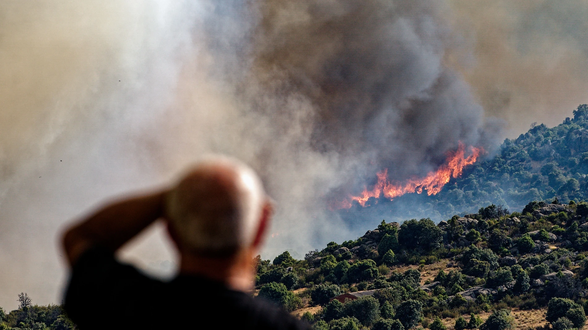 NAVALUENGA (ÁVILA), 18/07/2025.- Un hombre contempla un incendio forestal declarado en el término municipal de Navaluenga (Ávila), este viernes. EFE/ Raúl Sanchidrián