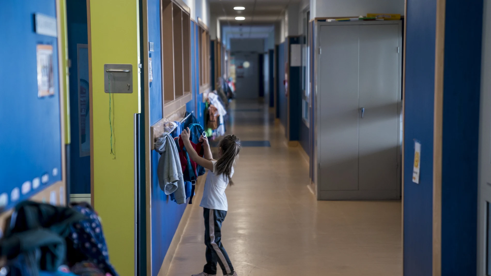Una niña cuelga su mochila en un perchero en un colegio público de Madrid.