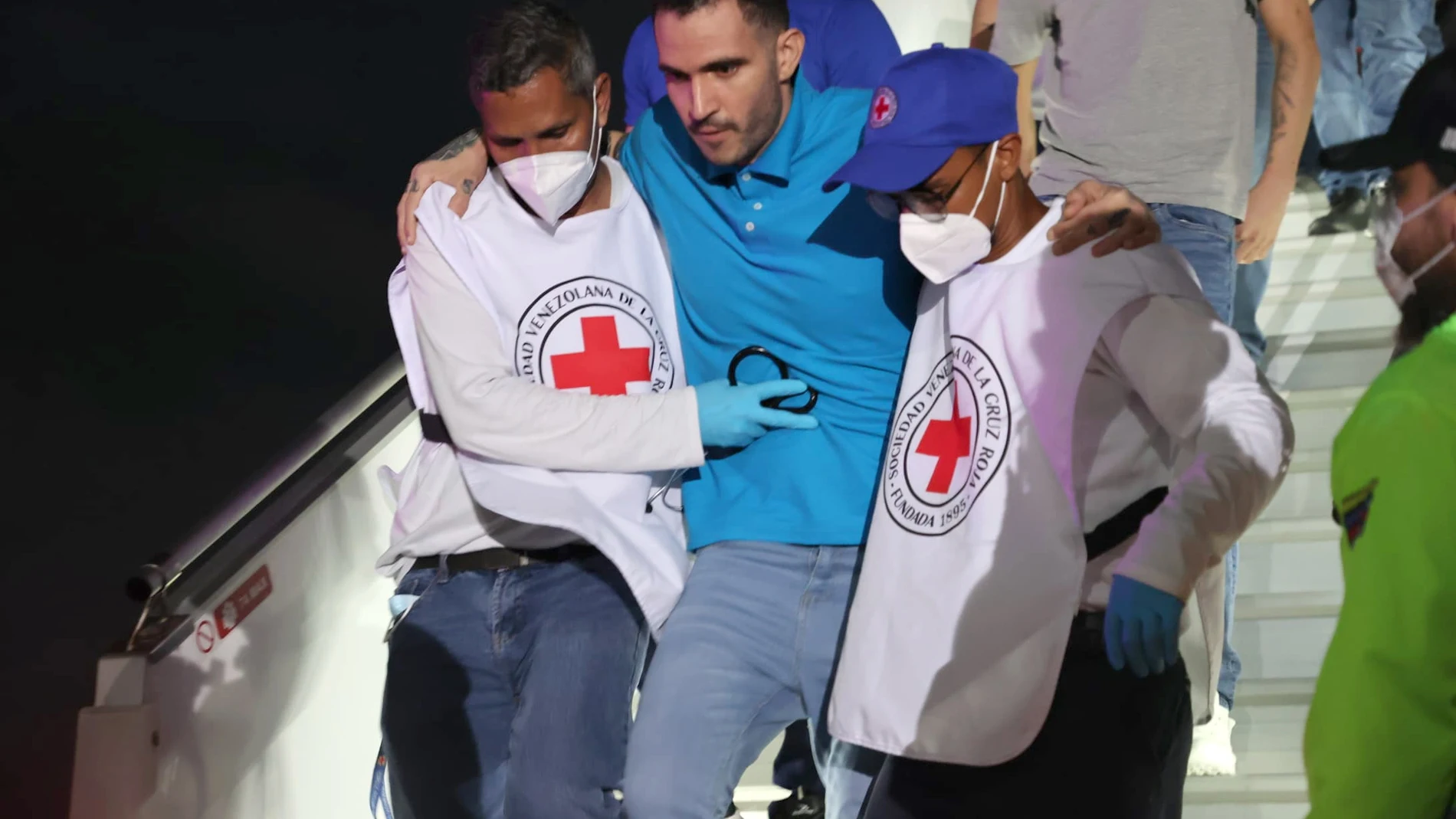 AME3830. MAIQUETÍA (VENEZUELA), 18/07/2025.- Fotografía cedida por el Ministerio del Poder Popular para Relaciones Interiores, Justicia y Paz de Venezuela, donde aparecen integrantes de la Cruz roja ayudando a un migrante deportado este viernes, en el Aeropuerto Internacional Simón Bolívar en Maiquetía (Venezuela). El presidente de Venezuela, Nicolás Maduro, anunció la llegada de migrantes deportados desde Estados Unidos hasta una cárcel de El Salvador, acusados de ser presuntos miembros de l...