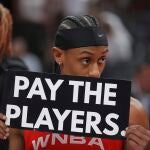 Sykes, jugadora de las Mystics, con el cartel reclamando mejoras salariales en la WNBA