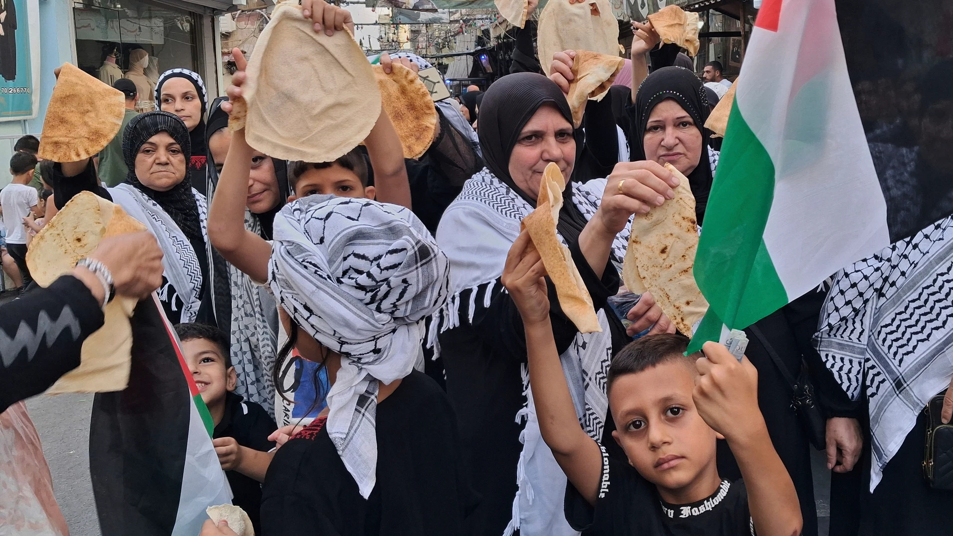 Palestinians hold pieces of bread during a protest at the Ein el-Hilweh refugee camp in the southern port city of Sidon, Lebanon, Sunday, July 20, 2025, in response to a global call for solidarity with Palestinians during Israel's war against Hamas in the Gaza Strip and to denounce Israel's siege of the enclave. (AP Photo/Mohammad Zaatari)