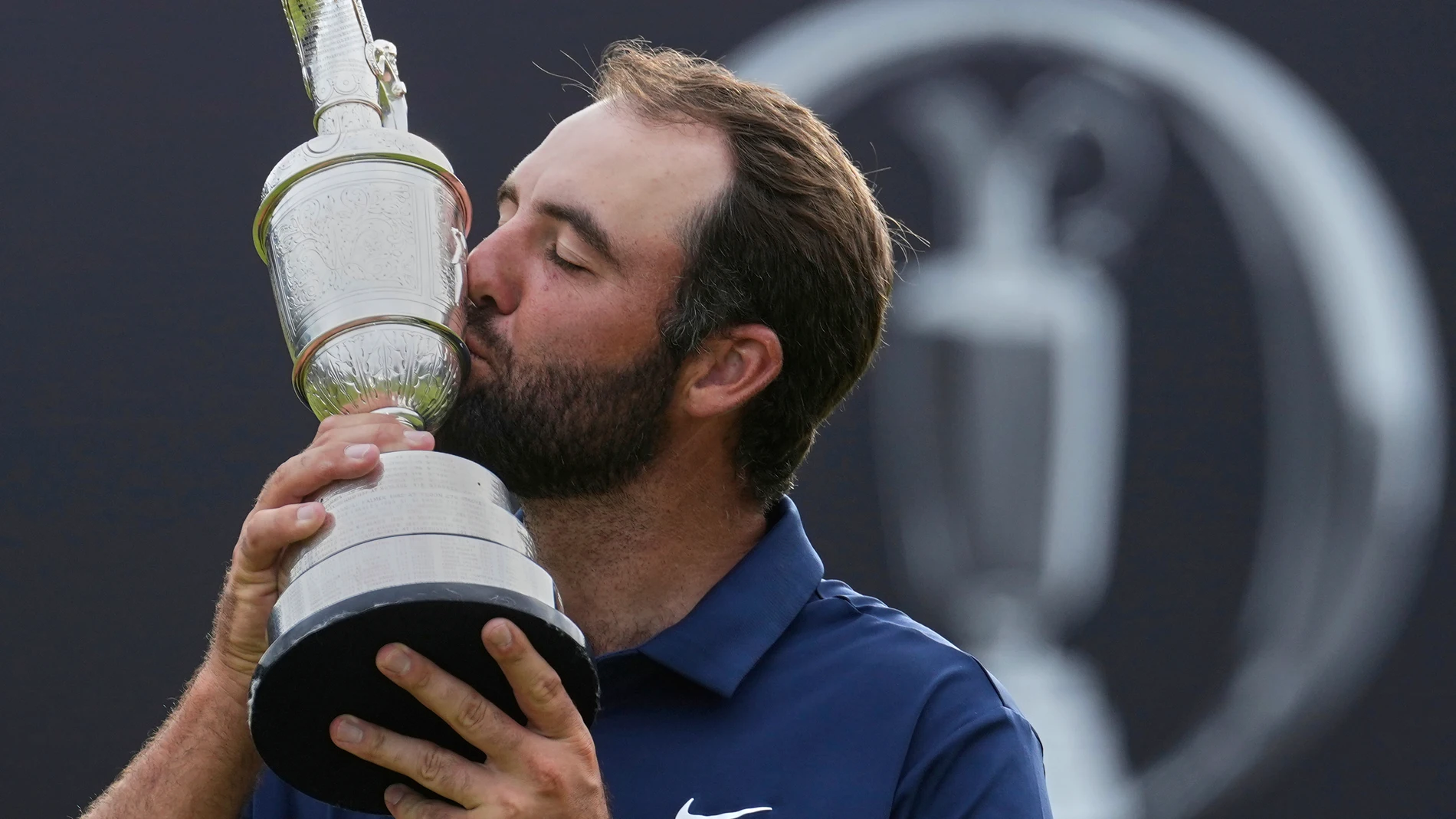 Scottie Scheffler of the United States kisses the Claret Jug trophy as he poses for photographers after winning the British Open golf championship at the Royal Portrush Golf Club, Northern Ireland, Sunday, July 20, 2025. (AP Photo/Jon Super)