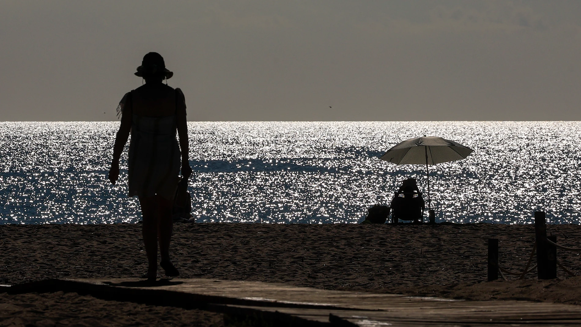 GRAFCVA8740. VALENCIA, 21/07/2025.- Dos personas disfrutan de la playa de El Saler durante este lunes en el que el cielo de la Comunitat Valenciana estará despejado por la mañana y con intervalos de nubes bajas a partir de media tarde en Castellón y Valencia, las temperaturas mínimas subirán en el litoral y prelitoral y las máximas descenderán de forma notable en el litoral de Valencia y del sur de Castellón pero serán significativamente altas en el prelitoral sur de Alicante. EFE/Kai Förster...