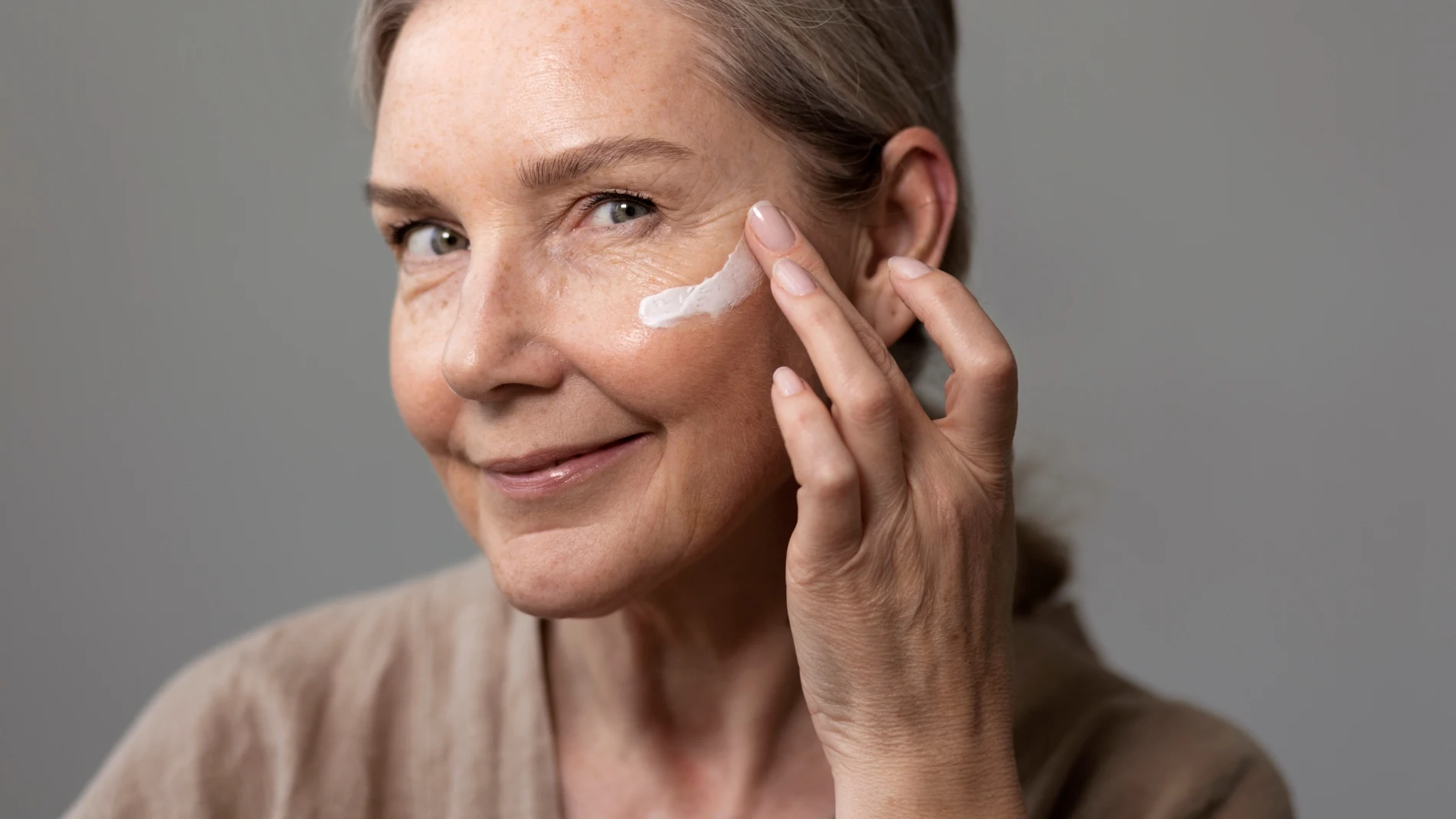 Mujer madura aplicándose crema