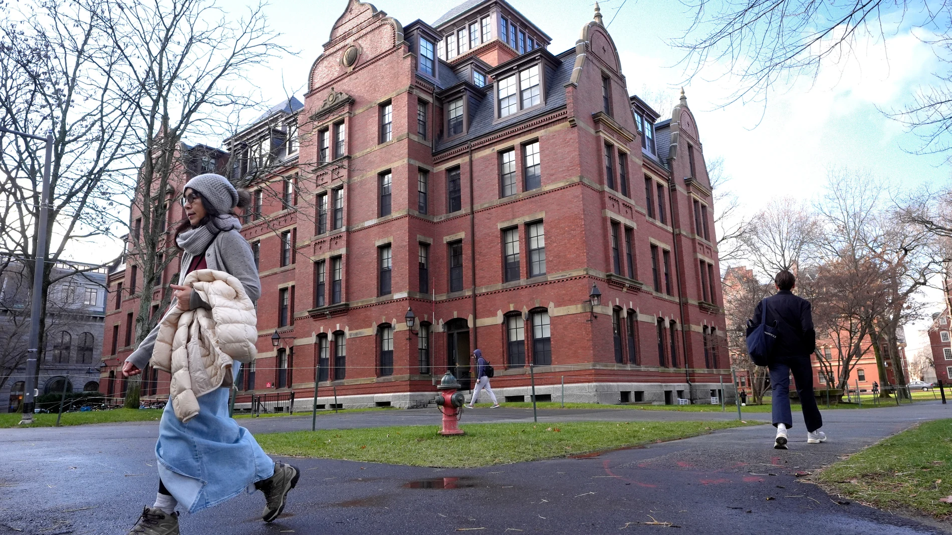 FILE - People walk between buildings on Harvard University campus, Dec. 17, 2024, in Cambridge, Mass. (AP Photo/Steven Senne, File)