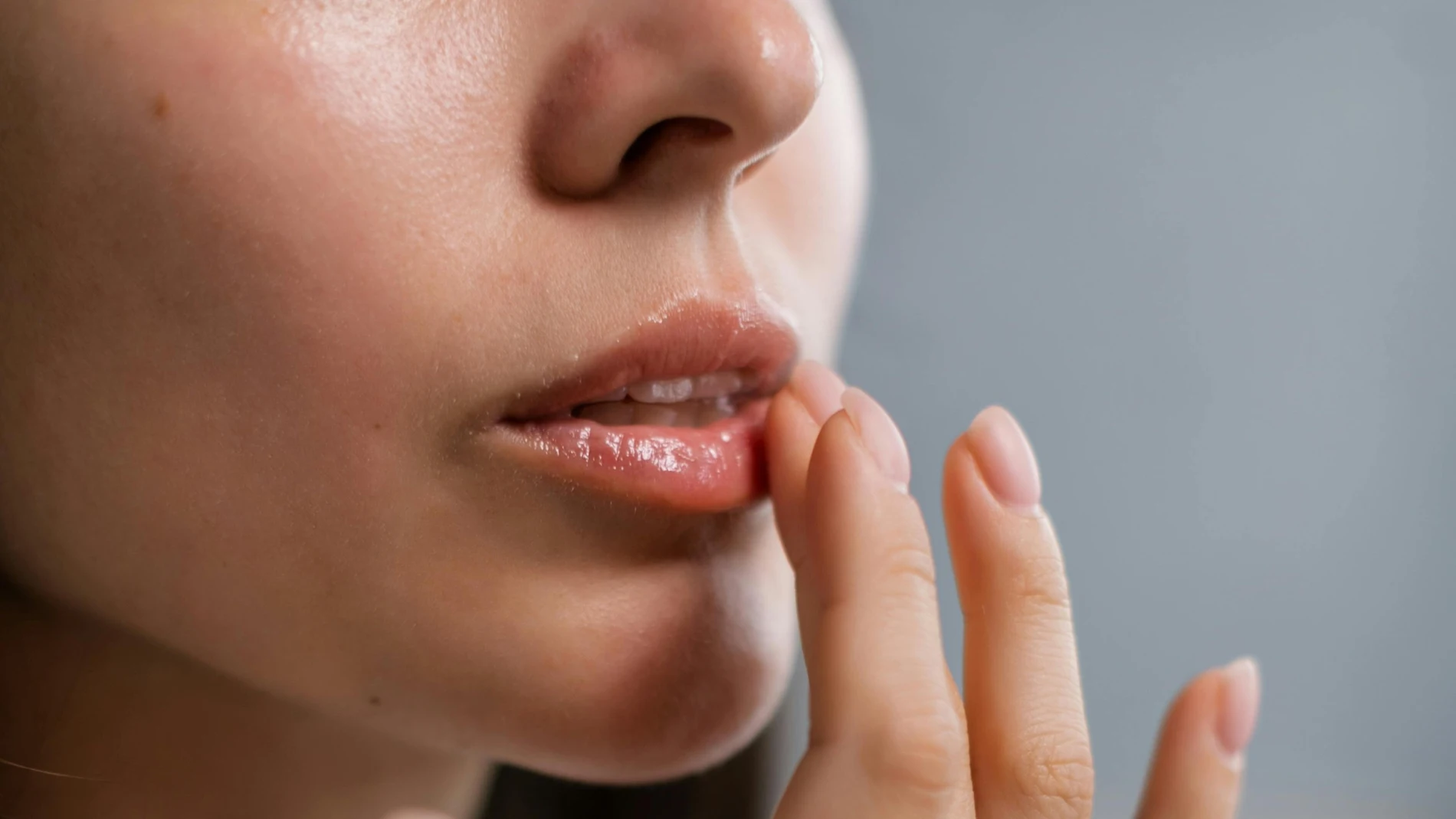 Labios con brillo natural tras aplicar gloss con los dedos.