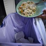 Una persona tira a la basura comida