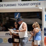 Varios turistas caminan por el centro de Málaga y piden información en la Oficina de Turismo de la ciudad en un día de calor sofocante 