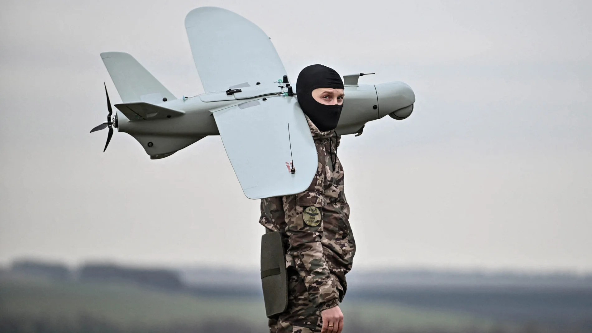 Aparece un soldado con un pasamontañas y cargando un dron a sus espaldas