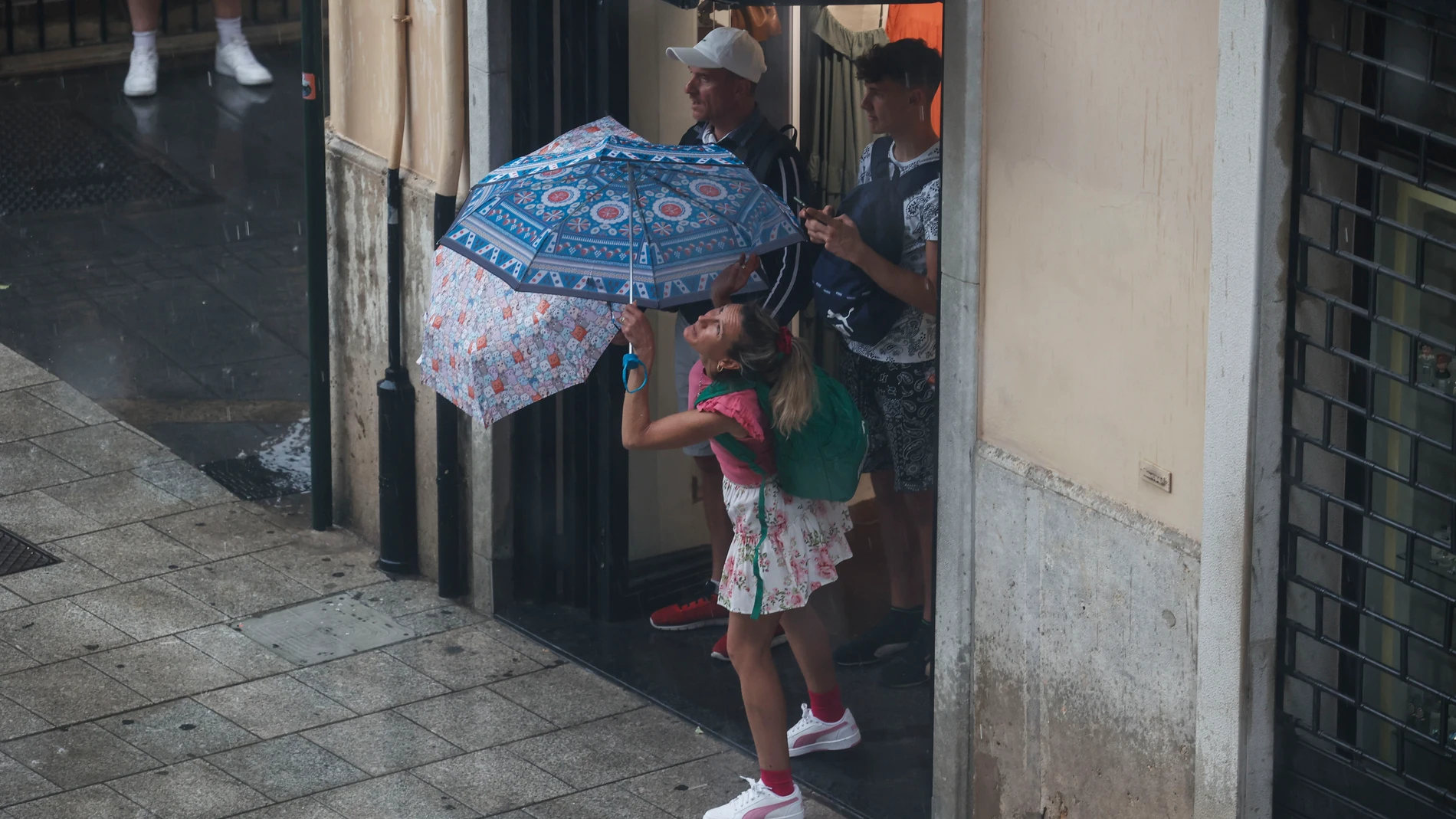 MANISES (VALÈNCIA), 24/07/2025.- varias personas se protegen de la lluvia este jueves en València. Aemet ha establecido el aviso amarillo por lluvia y tormentas en Alicante y Valencia este jueves y también por fenómenos costeros en Alicante. EFE/ BIEL ALIÑO