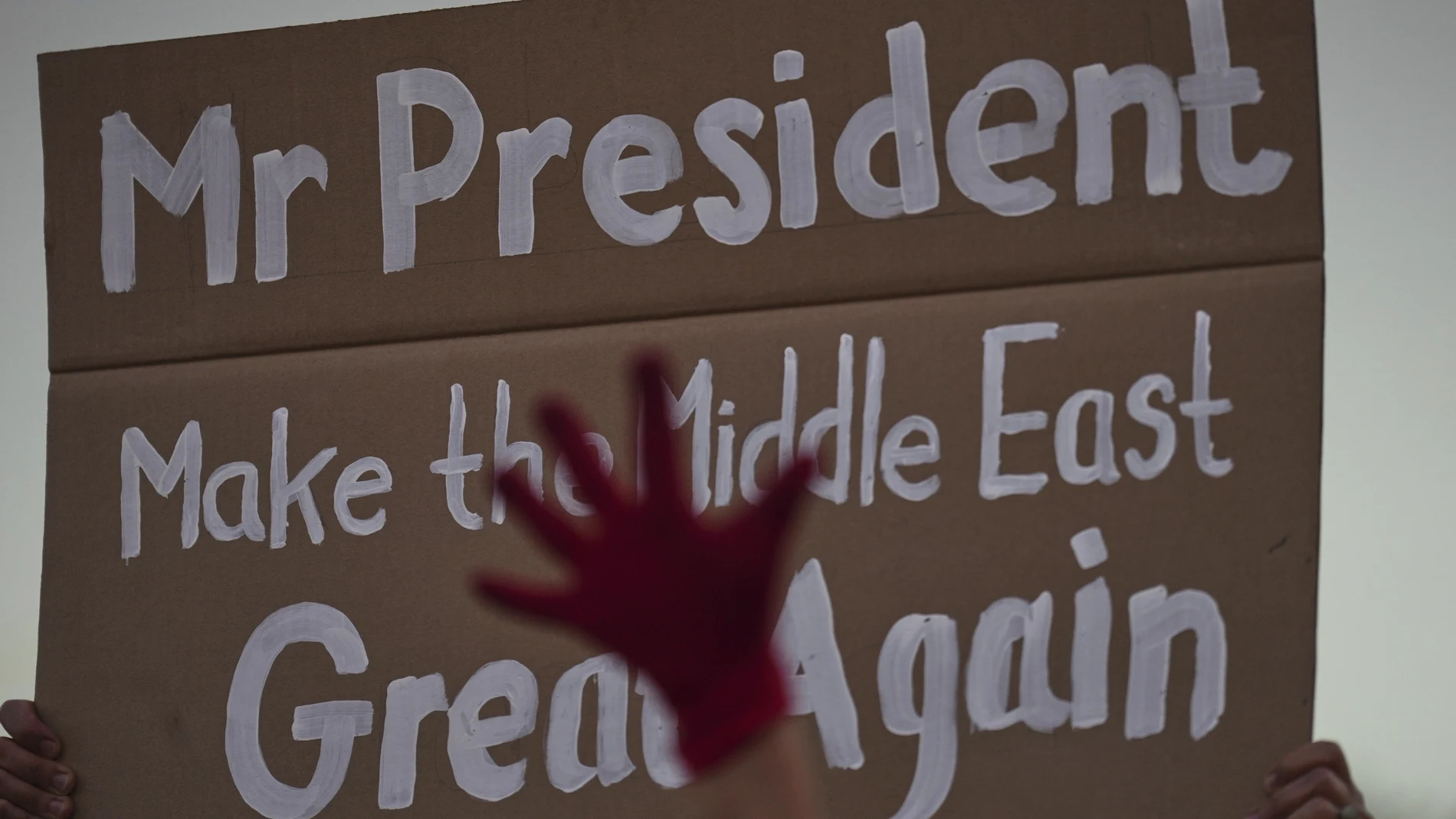 A demonstrator holds a sign with a message to the U.S. President Donald Trump during a rally calling for the end of the war and immediate release of hostages held by Hamas in the Gaza Strip, in Tel Aviv, Israel, Thursday, July 24, 2025. (AP Photo/Ariel Schalit)