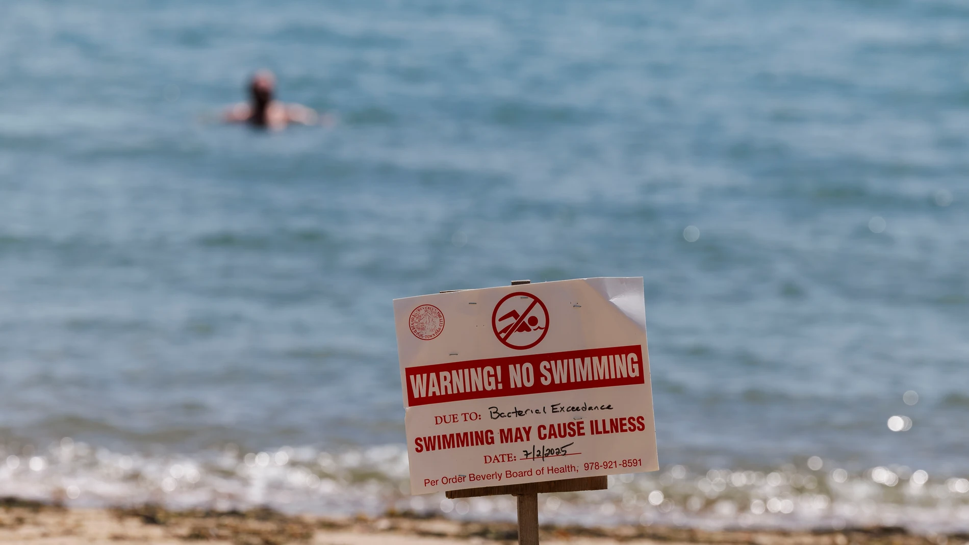 BEVERLY (United States), 24/07/2025.- Signage warns bathers not to swim due to high bacteria levels in the water at Brackenbury Beach in Beverly, Massachusetts, USA, 24 July 2025. With extreme high temperatures and high humidity levels projected to return in the coming days to the region, over 30 beaches remain closed by the Health Department in the Commonwealth of Massachusetts to due elevated bacteria levels or a harmful cyanobacteria bloom. EFE/EPA/CJ GUNTHER