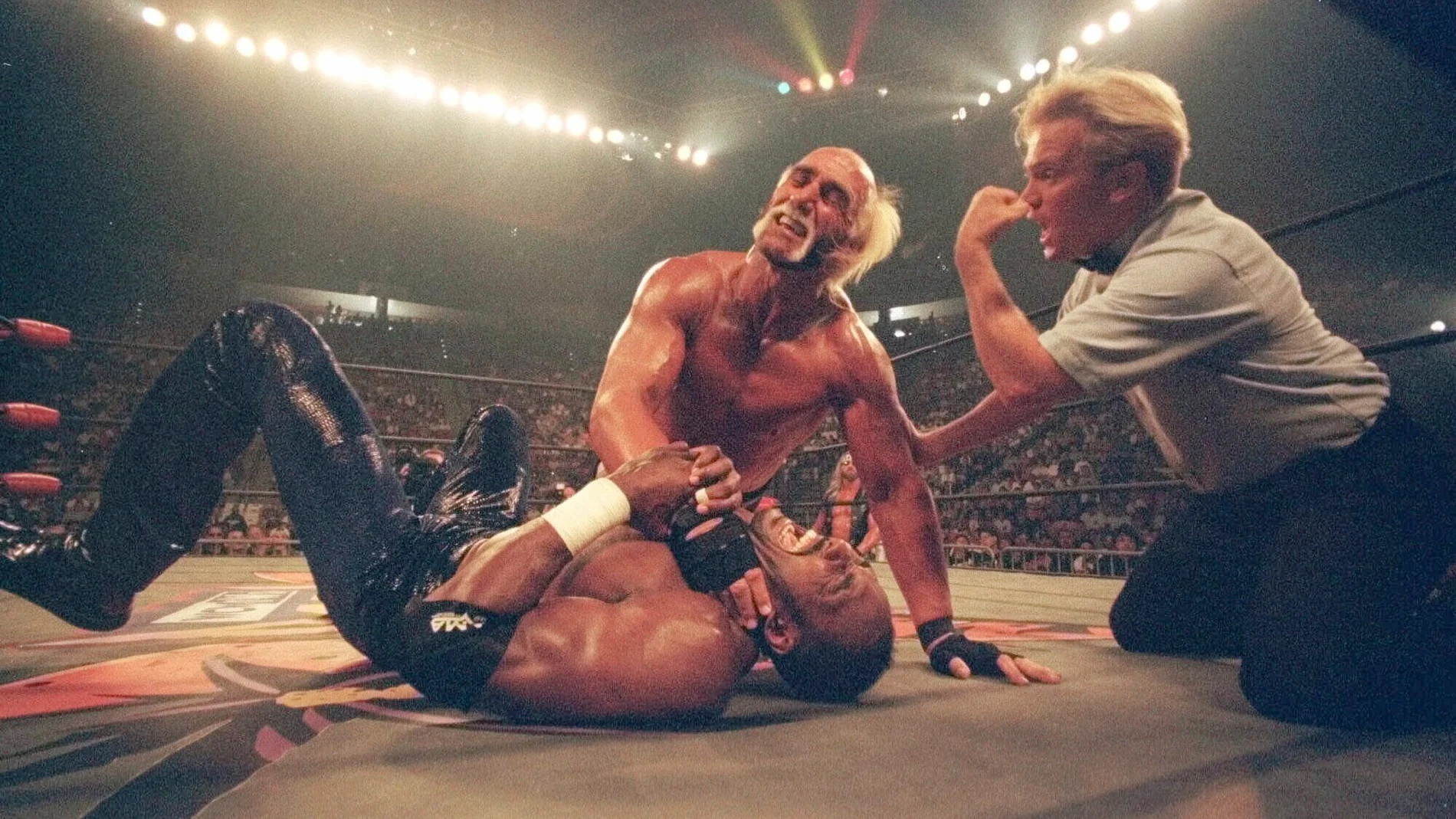 FILE - Hollywood Hulk Hogan puts a choke hold on the neck of Utah Jazz basketball star Karl Malone at a pay-per-view wrestling match July 12, 1998 in San Diego. (AP Photo/Lenny Ignelzi, File)