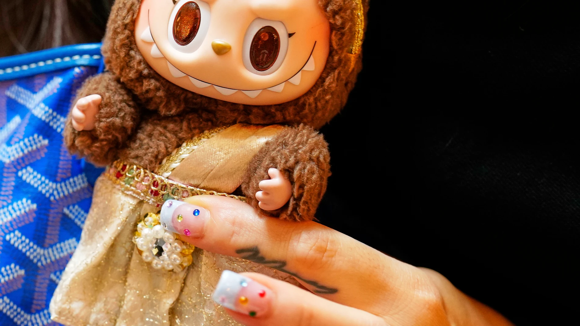 Diep Nguyen shows a Labubu doll to media during the opening of Germany's first shop for Labubu plush dolls in Berlin, Germany, Friday, July 25, 2025. (AP Photo/Markus Schreiber)