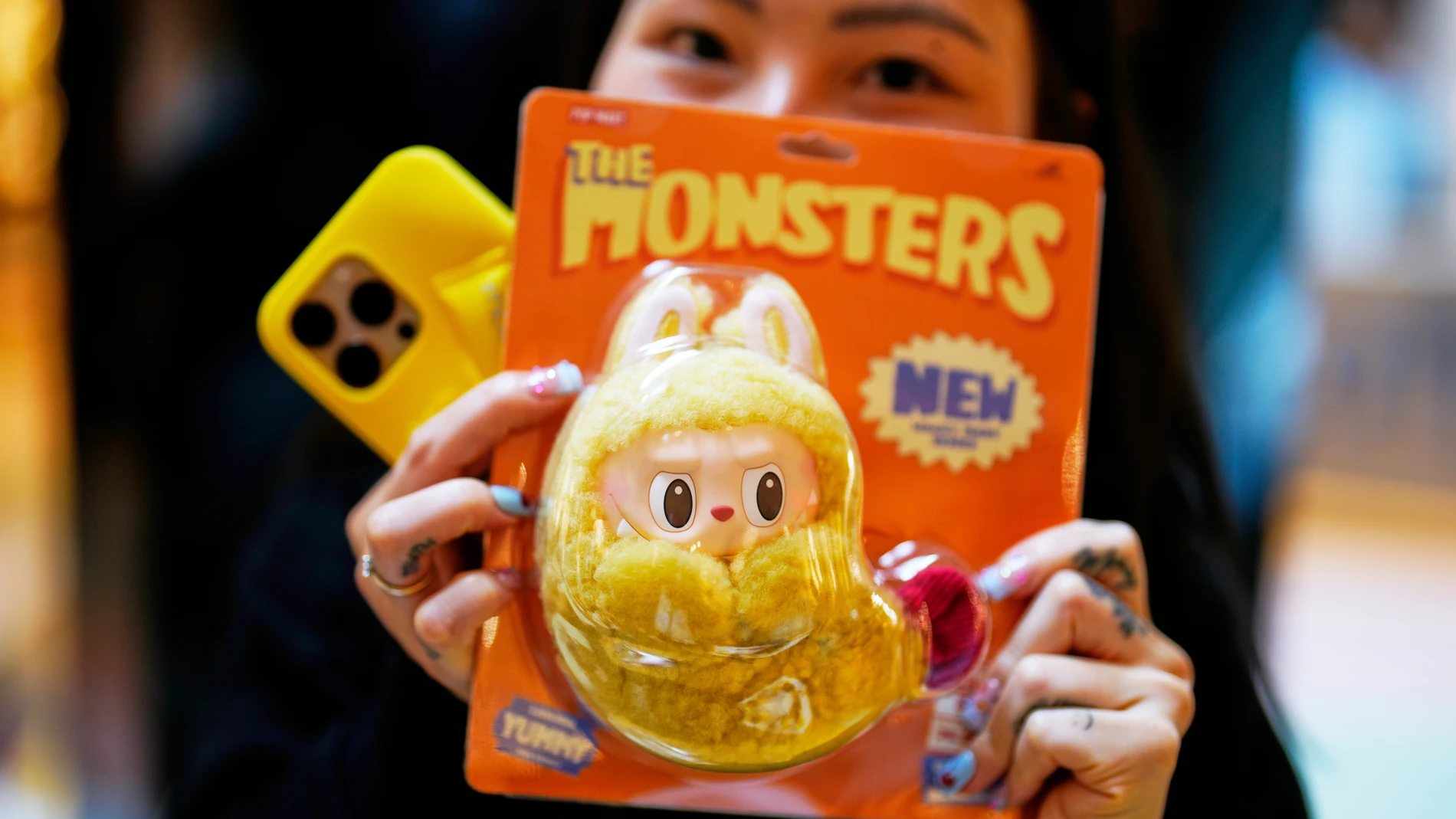 Diep Nguyen shows her new Labubu doll to media during the opening of Germany's first shop for Labubu plush dolls in Berlin, Germany, Friday, July 25, 2025. (AP Photo/Markus Schreiber)