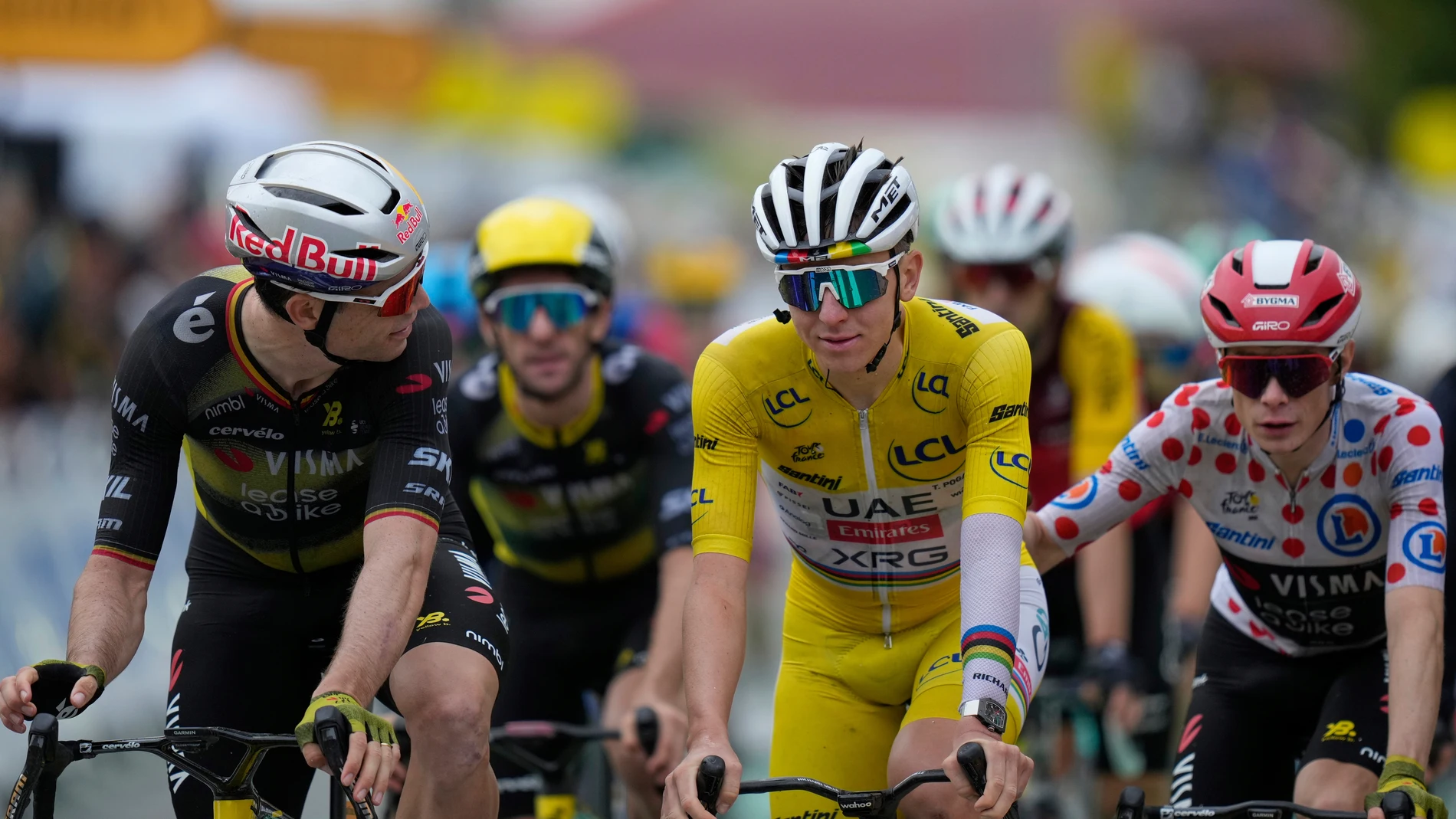 Denmark's Jonas Vingegaard, wearing the best climber's dotted jersey, pats Slovenia's Tadej Pogacar, wearing the overall leader's yellow jersey, as they cross the finish line with Belgium's Wout van Aert, left, during the twentieth stage of the Tour de France cycling race over 184.2 kilometers (114.5 miles) with start in Nantua and finish in Pontarlier, France, Saturday, July 26, 2025. (AP Photo/Mosa'ab Elshamy)