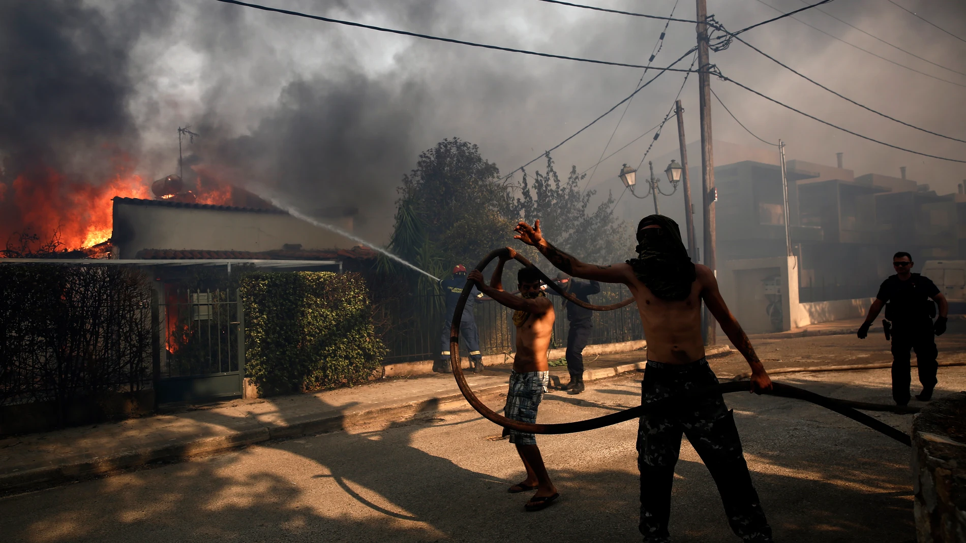 FOTODELDIA Atenas, 26/07/2025.- Bomberos y voluntarios trabajan en las tareas de extinción del fuego en la localidad de Kryoneri que ha obligado a evacuar a la población, este sábado. EFE/YANNIS KOLESIDIS