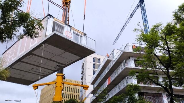 Imagen del momento en que se añade un módulo tridimensional al edificio en construcción de una promoción de vivienda protegida en Barcelona.