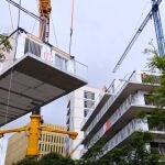 Imagen del momento en que se añade un módulo tridimensional al edificio en construcción de una promoción de vivienda protegida en Barcelona.