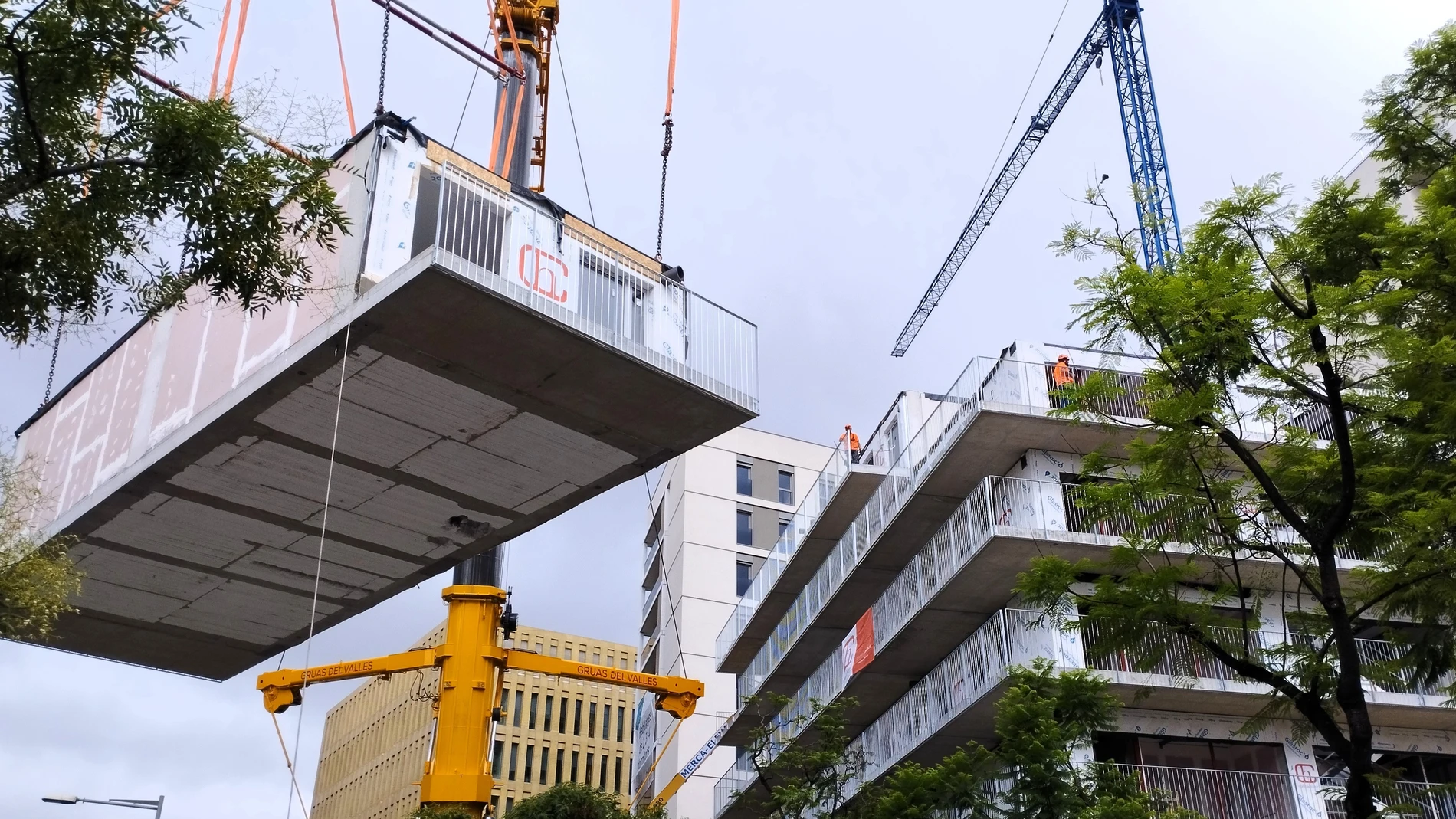 Imagen del momento en que se añade un módulo tridimensional al edificio en construcción de una promoción de vivienda protegida en Barcelona. EUROPA PRESS 28/07/2025