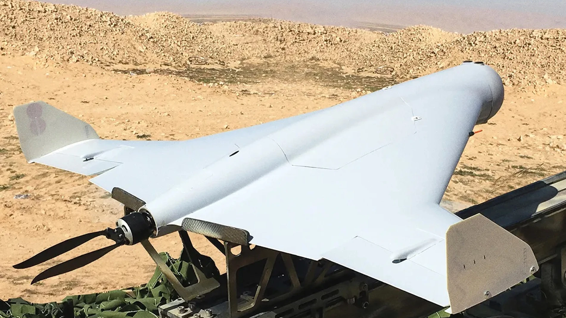 Dron con forma de ala delta triangular a punto de ser lanzado desde un sistema de vuelo