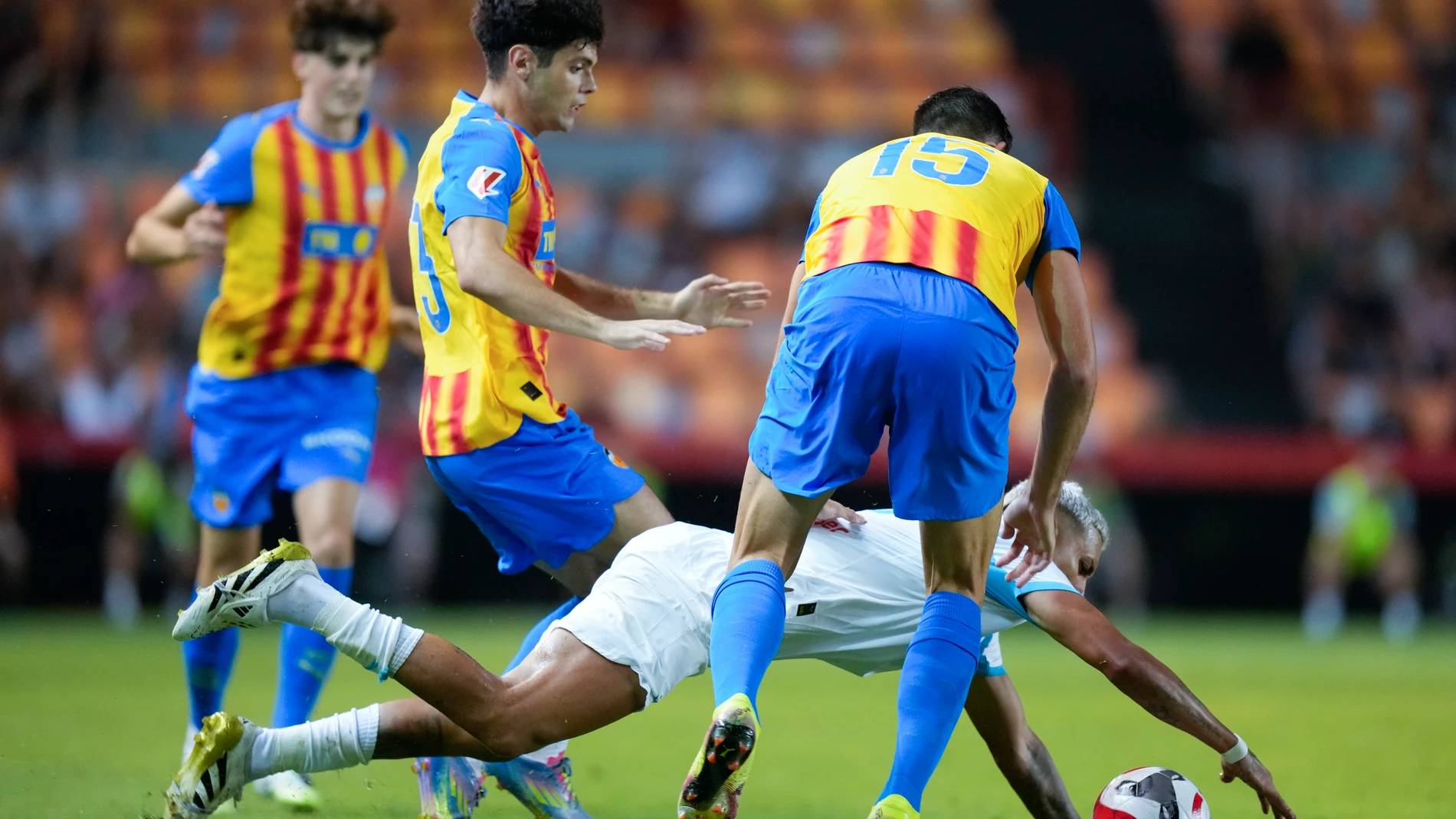 TARRAGONA, 29/07/2025.- El defensa del Olympique Facundo Medina cae entre Fran Pérez (2-i) y César Tárrega (d), ambos del Valencia, durante el partido amistoso que Valencia CF y Olympique Marsella disputan este martes en el Nou Estadi Costa Daurada, en Tarragona. EFE/Enric Fontcuberta