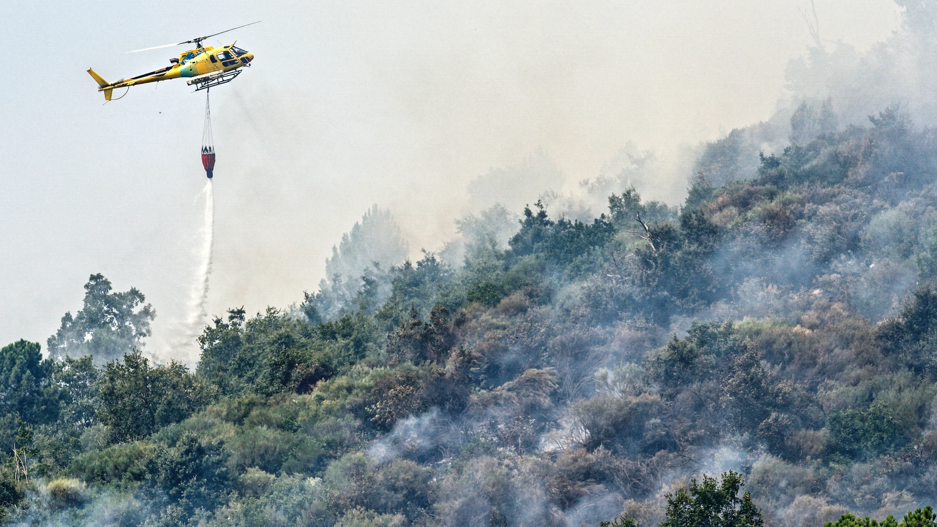 FOTODELDÍA MOMBELTRÁN (ÁVILA), 31/07/2025.-Un helicóptero trabaja en las labores de extinción del incendio en Mombeltrán (Ávila). La Junta de Castilla y León ha puesto fin al confinamiento decretado en los municipios abulenses de Mombeltrán y El Arenal por el humo y las cenizas del incendio que afecta a esta zona del sur de Ávila que, si bien se mantiene activo con unas 2.000 hectáreas ya quemadas, su evolución es favorable. Esta medida ha afectado a cerca de 4.000 personas que durante estos ...