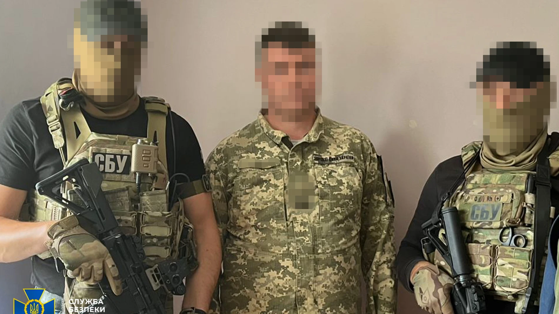 El sospechoso de traición escoltado por dos agentes del SBU