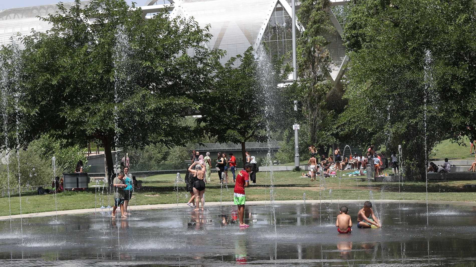 Gente refrescandose en las fuentes de los parques públicos, debido a las altas temperaturas.
