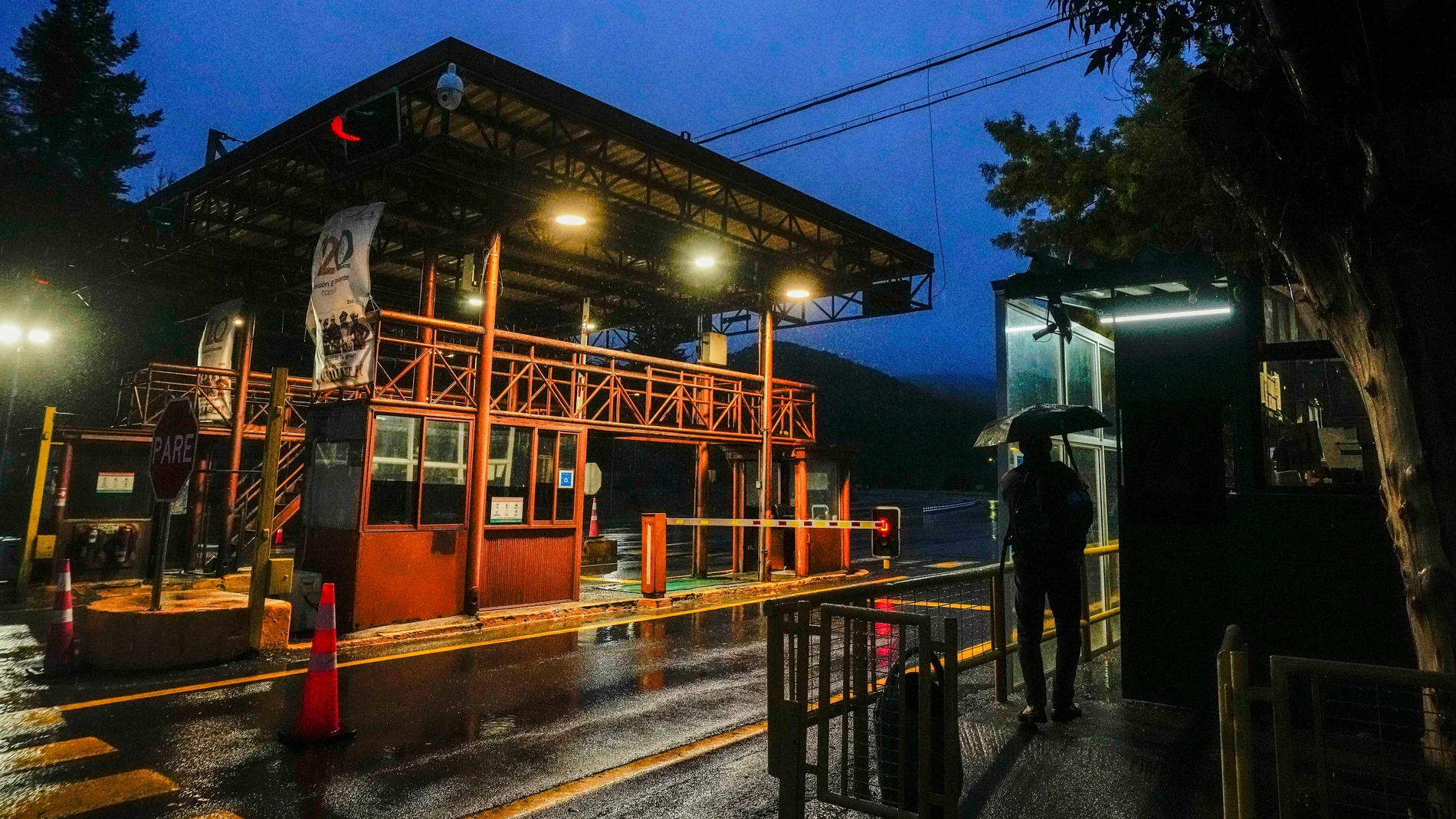 A man stands at the entrance of El Teniente copper mine, operated by Codelco, where a collapse killed one worker and trapped five others underground, leading to a suspension of operations in Rancagua Chile, Friday, Aug. 1, 2025. (AP Photo/Esteban Felix)