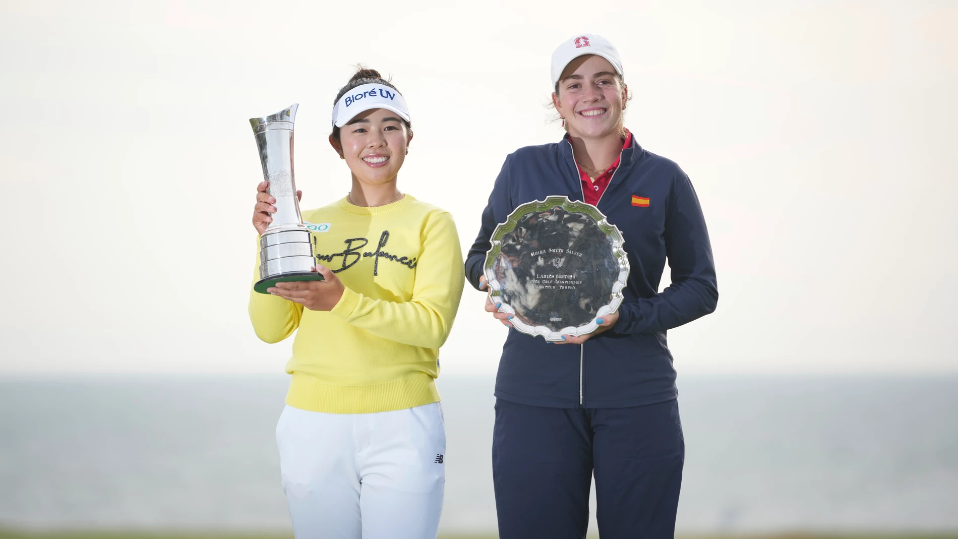 Miyu Yamashita, left, of Japan, winner of the Women's British Open golf championship, and Paula Martin Sampedro of Spain amateur winner, pose with their trophies, at Royal Porthcawl Golf Club in Porthcawl, Wales, Sunday, Aug. 3, 2025. (AP Photo/Kin Cheung)