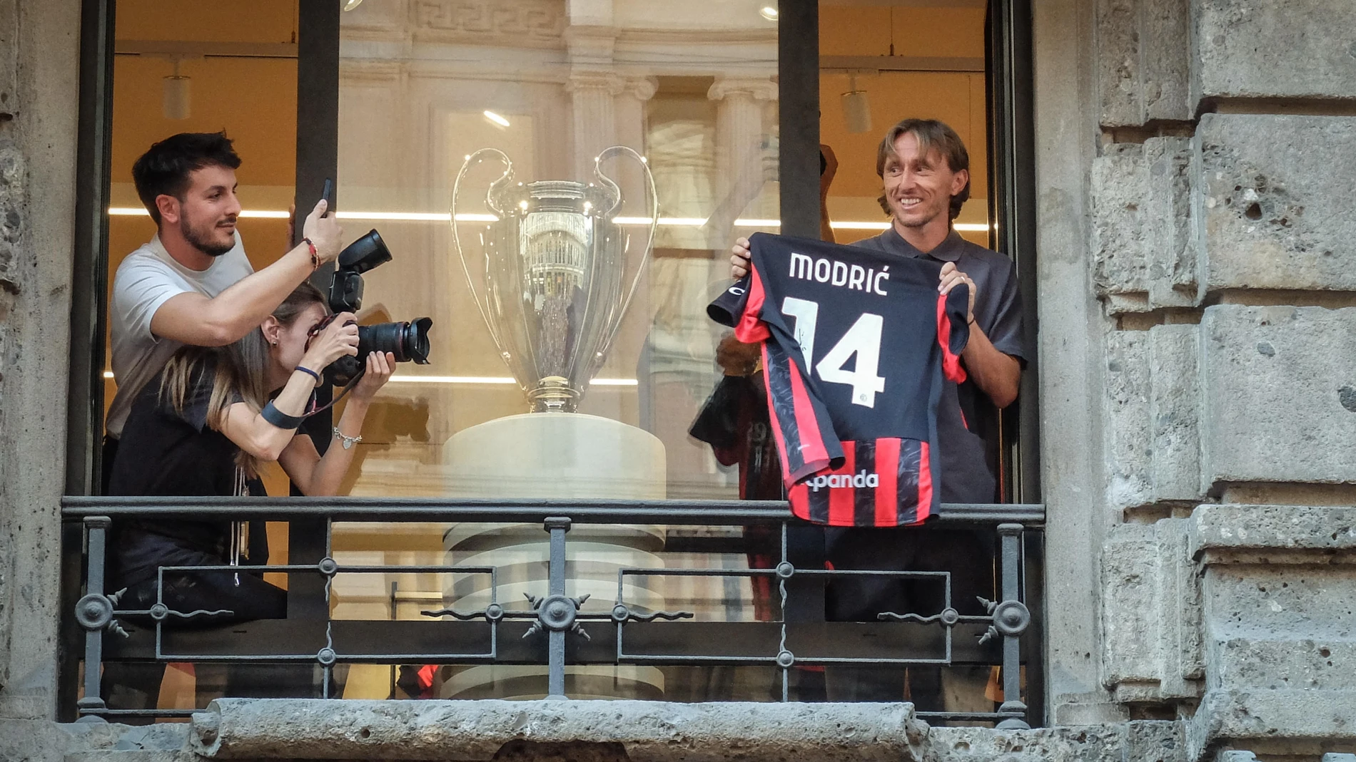 FOTODELDÍA MILÁN (ITALIA), 04/08/2025.- El nuevo fichaje del AC Milán, el croata Luka Modric, saluda a los aficionados con una camiseta del equipo desde la tienda oficial del club "rossonero", este lunes en Milán. EFE/MATTEO CORNER