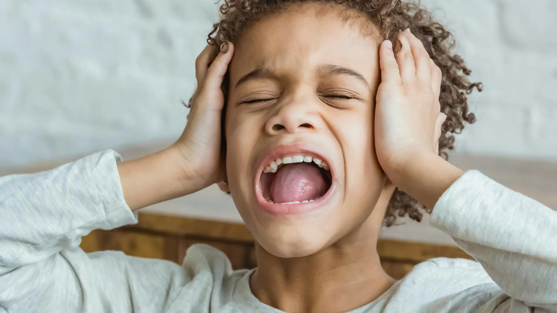 Niños tapándose los oídos con las manos