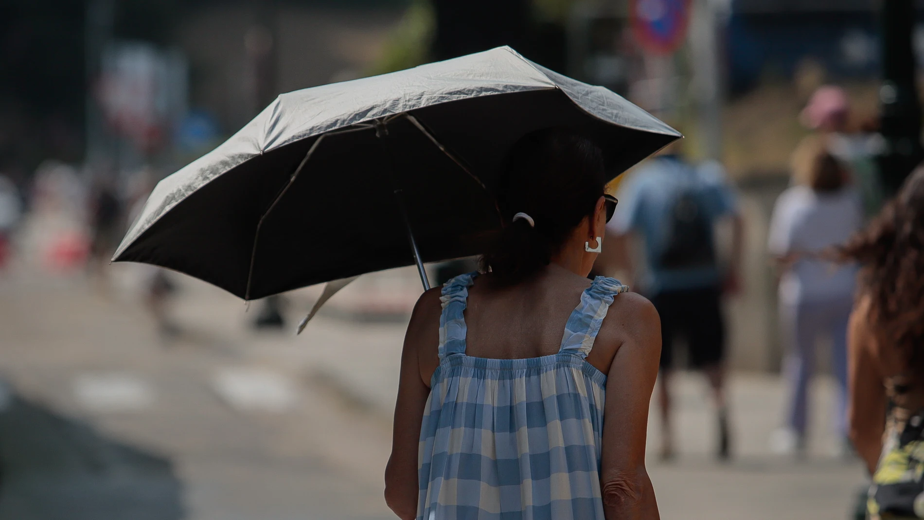 Una mujer se protege del sol con una sombrilla, a 5 de agosto de 2025, en Vigo, Pontevedra, Galicia (España). La Agencia Estatal de Meteorología (Aemet) ha activado avisos naranjas y amarillos en más de 30 provincias por temperaturas extremas durante el inicio de la canícula, el periodo estadísticamente más cálido del año. En más de la mitad del país se podrían alcanzar temperaturas extremas debido a una dorsal anticiclónica que ha generado cielos despejados y una masa de aire cálido que se ...